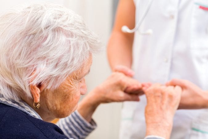 Old Woman getting help to stand up close up on hands