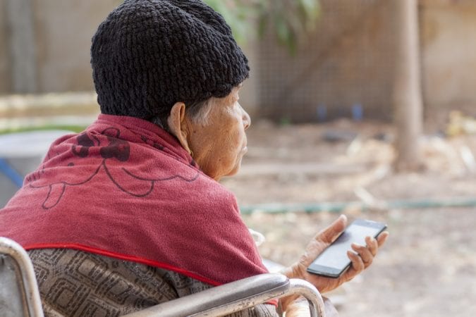 Old Woman Staring ahead and holding cell phone