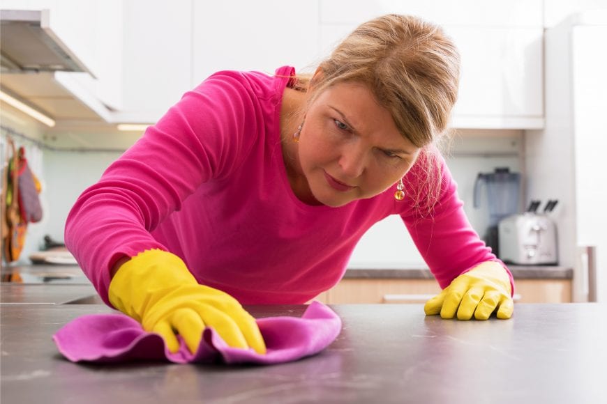 Woman scrubbing her kitchen counter OCD