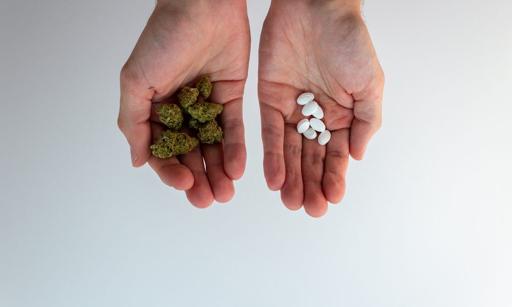 replace with cannabis represented by hands one holding cannabis and the other holding pills