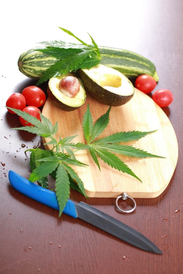 cannabis is a veggie represented by cannabis on cutting board with ovacado and tomatoes