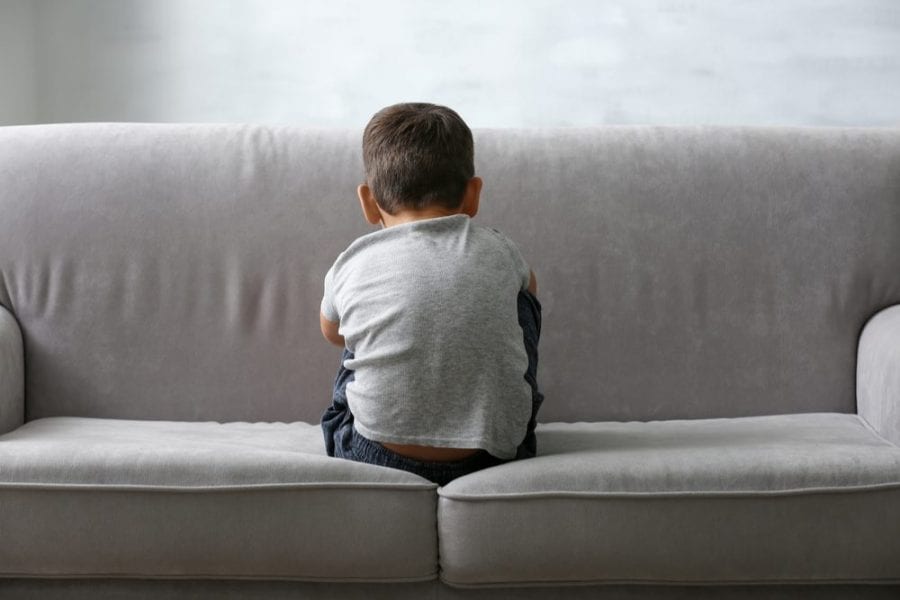 Small Autistic Boy With Back to Camera Sitting on a Couch