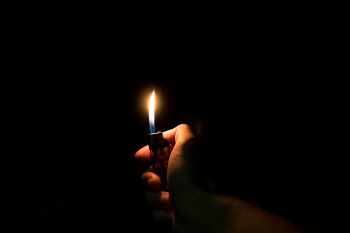 lit lighter in darkness