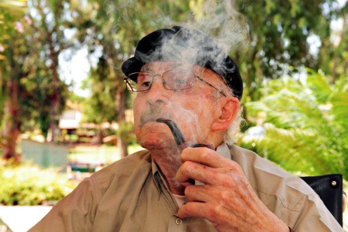 older adult smoking cannabis through a pipe