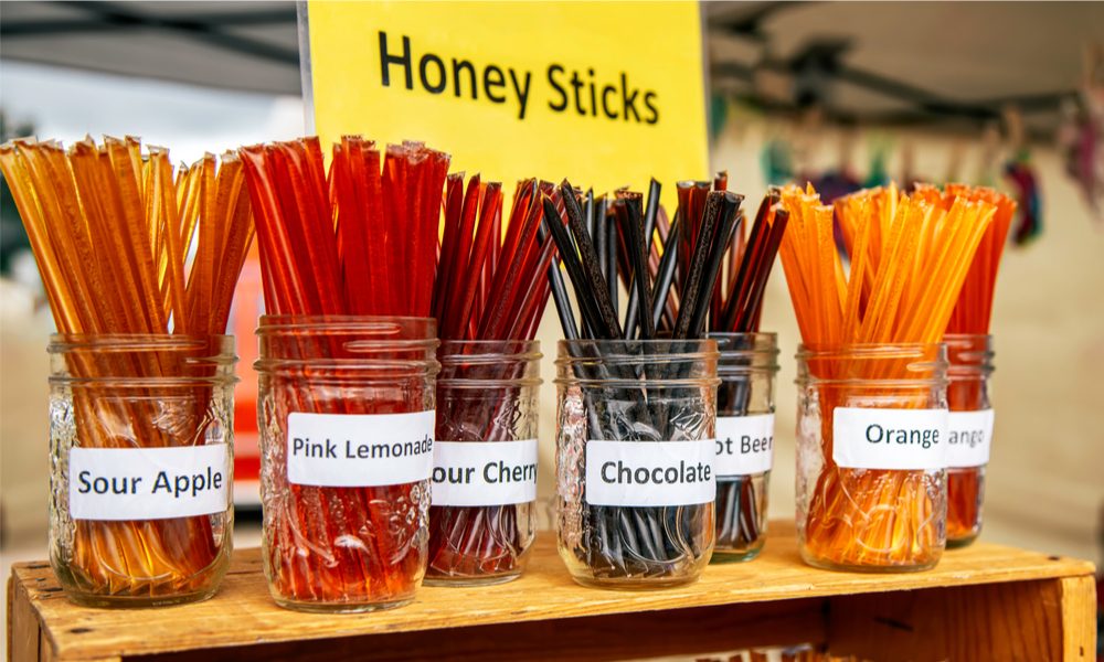 honey sticks represented by jars of flavoured honey sticks on display