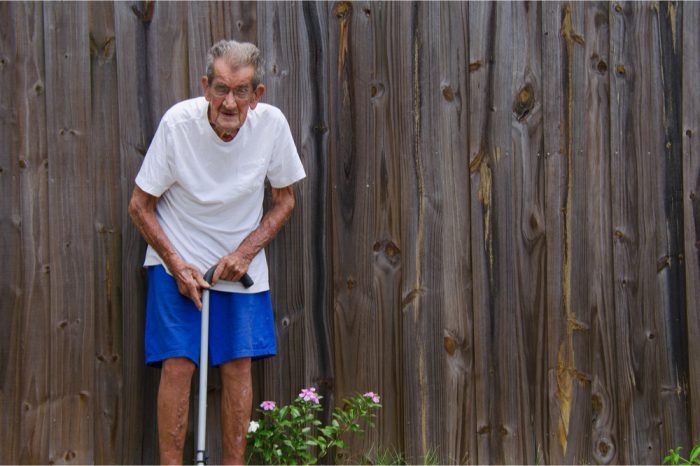 frail older adult uses cane 