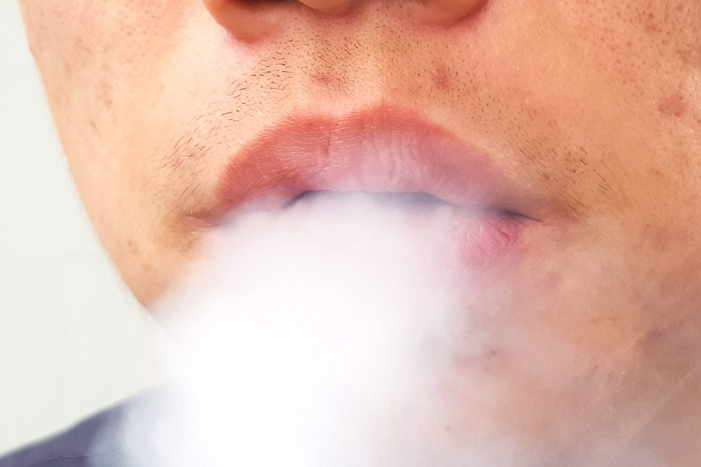 how to get rid of pimples represented by mouth of pimpled asian or latin man smoking cannabis