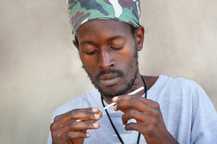 rastafarian man in jamaica looking at a joint
