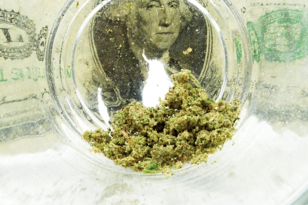 AMERICAN MADE REPRESENTED BY glass jar of weed over dollar bill with george washington