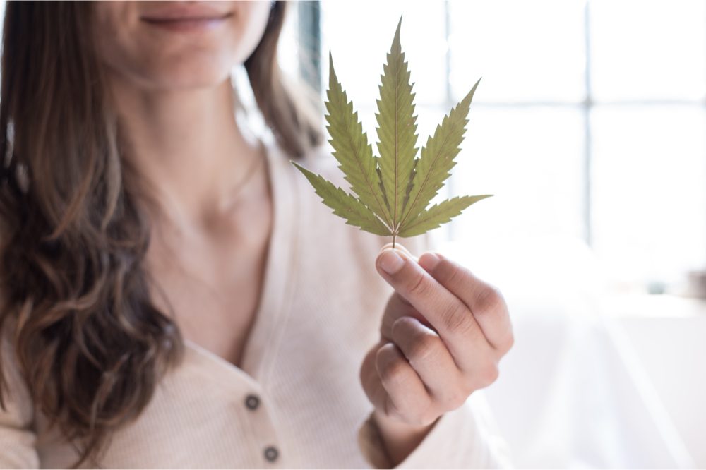 effects of thc on women represented by woman holding cannabis leaf