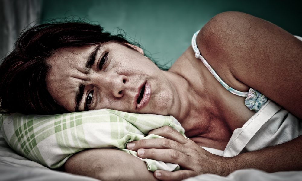 stop chronic pain represented by woman laying in bed in pain